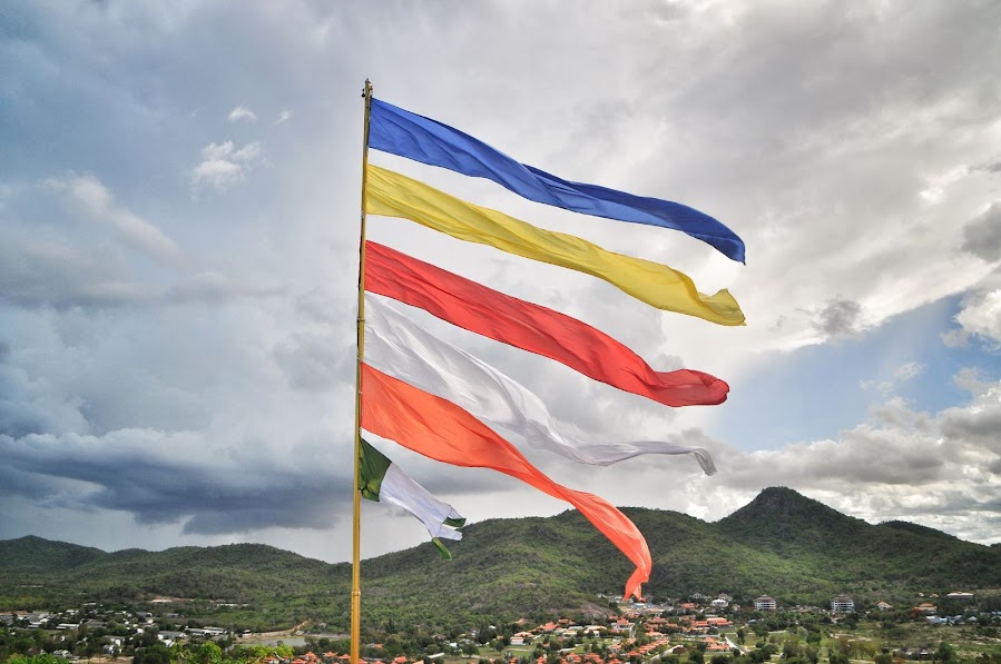 Vibrant buddhist flags and green mountain slopes thailand