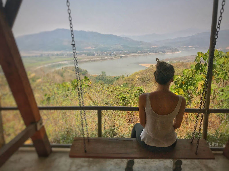 girl on swing before mekong river thailand