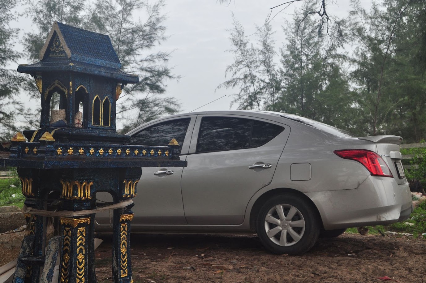 Singhanakorn Beach 
Songkhla Province
Thailand
Nissan car by a Thai shrine