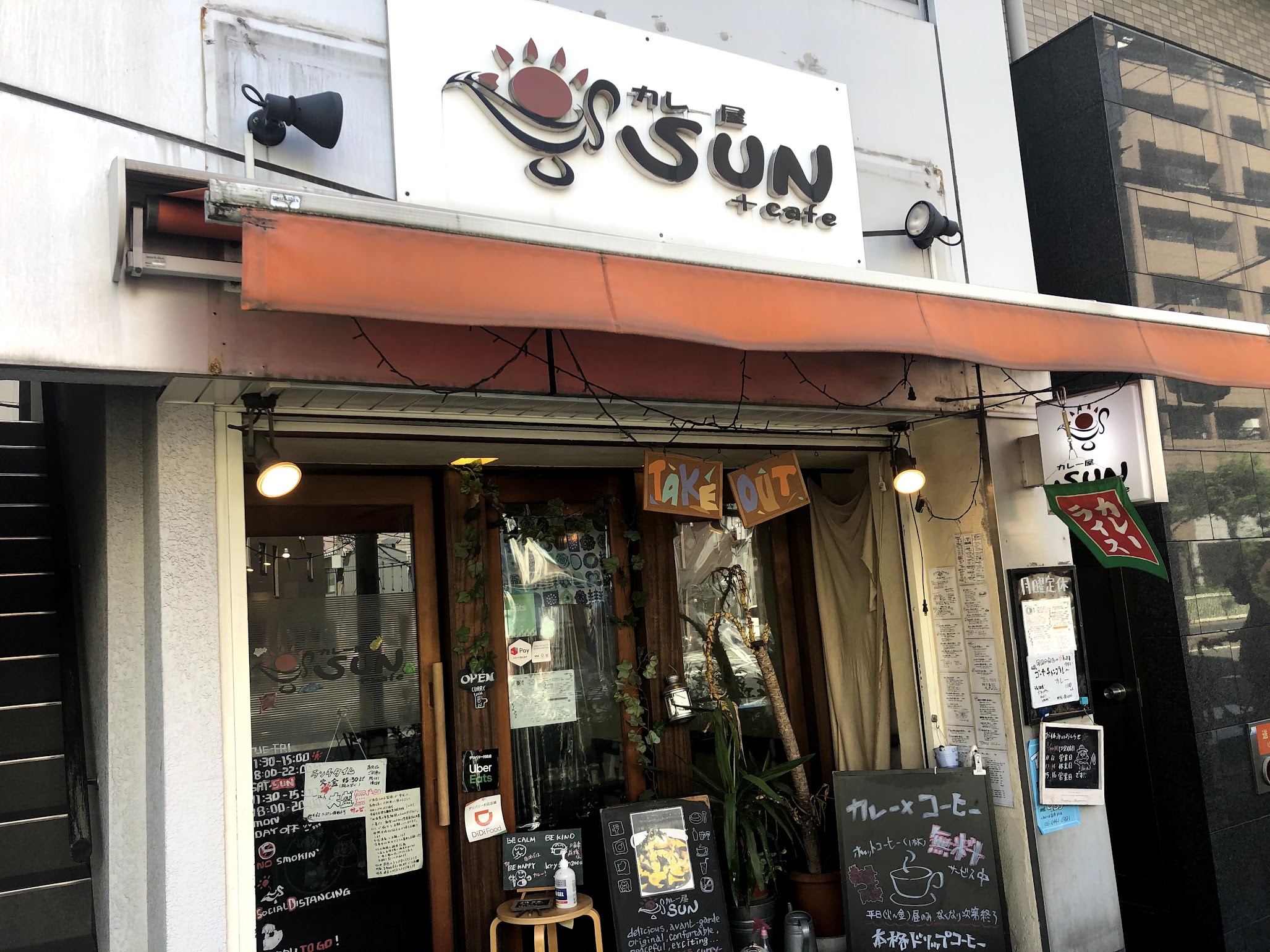 カレー屋SUNの白い看板が目立つ外観