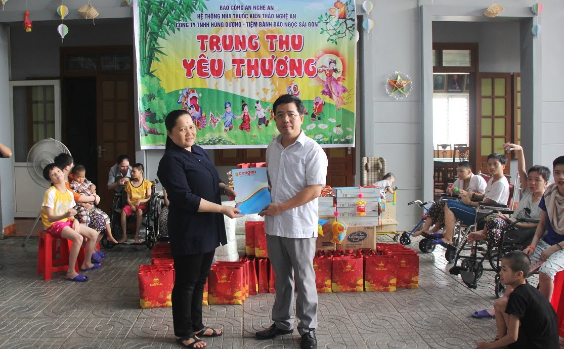 Đồng chí Thượng tá Nguyễn Xuân Thư - Trưởng phòng Báo Công an Nghệ An trao quà cho đại diện Trung tâm nuôi dưỡng trẻ mồ côi, khuyết tật, chất độc da cam 19/3.