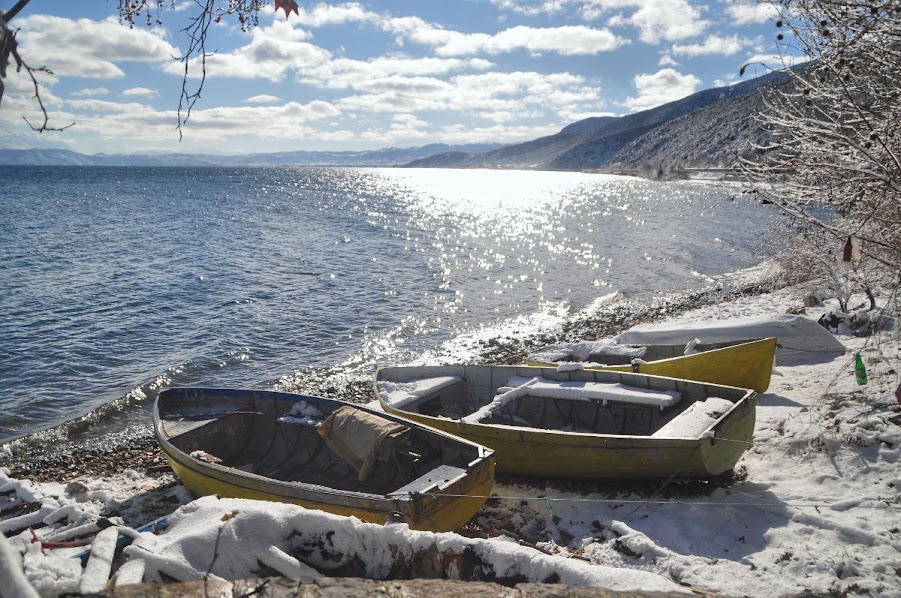 yellow boats on snow covered beach on the shore of lake ohrid albania