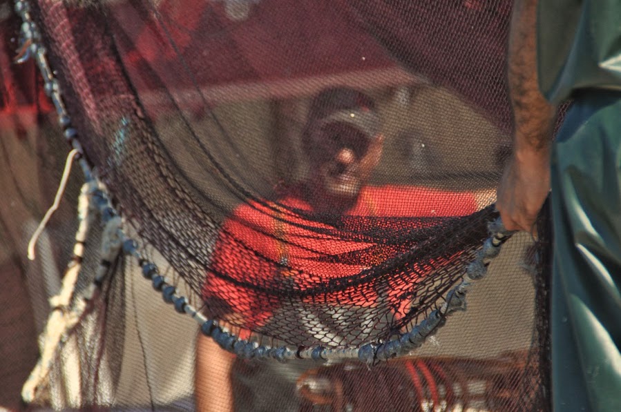 human portrait behind fishing net