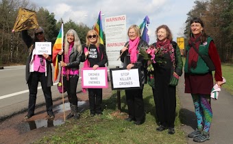 Friedensfreundinnen mit Fahnen und Schildern «Stop Killer Drones».