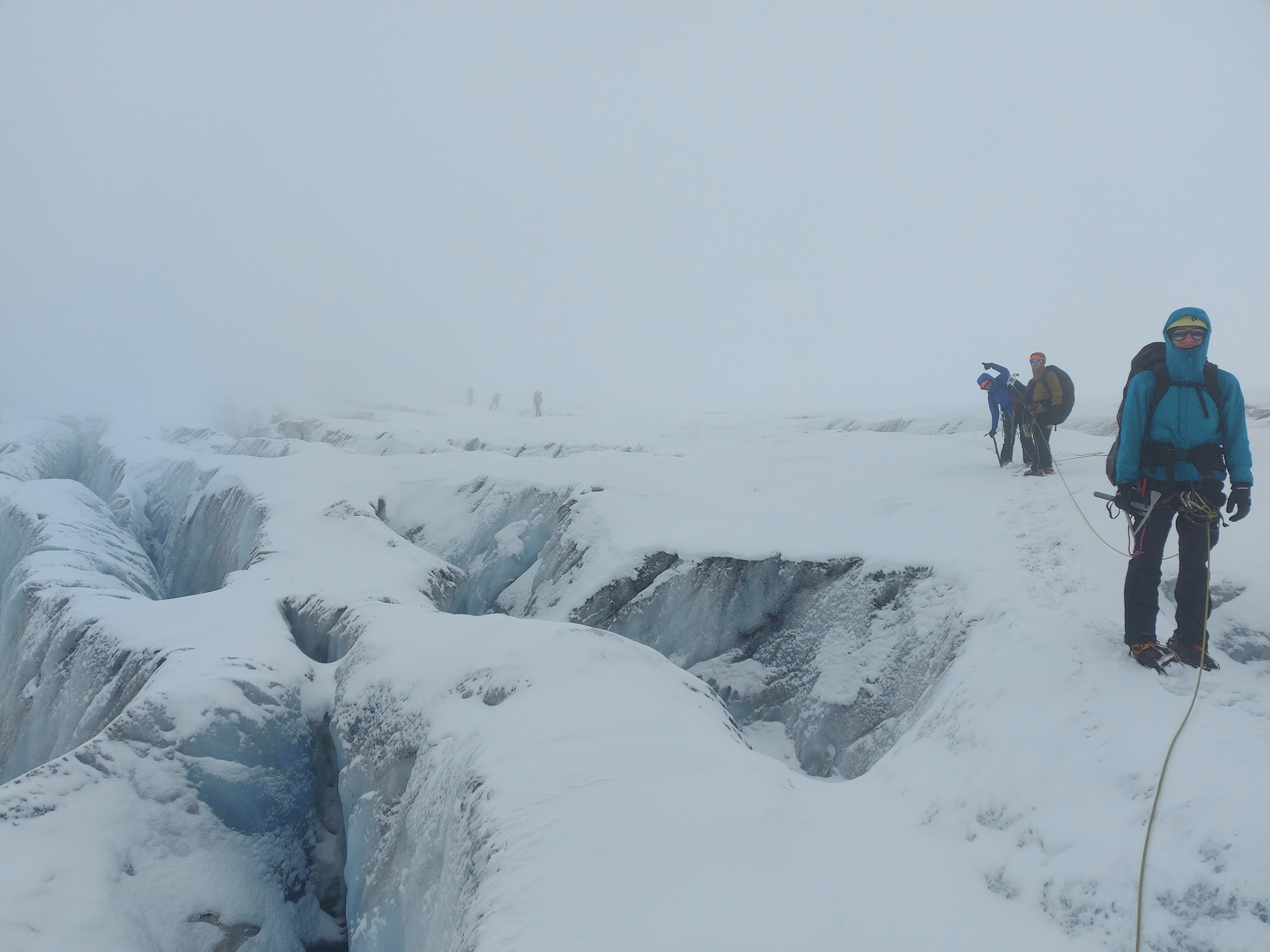 Team roped up, navigating crevasses in poor visibility