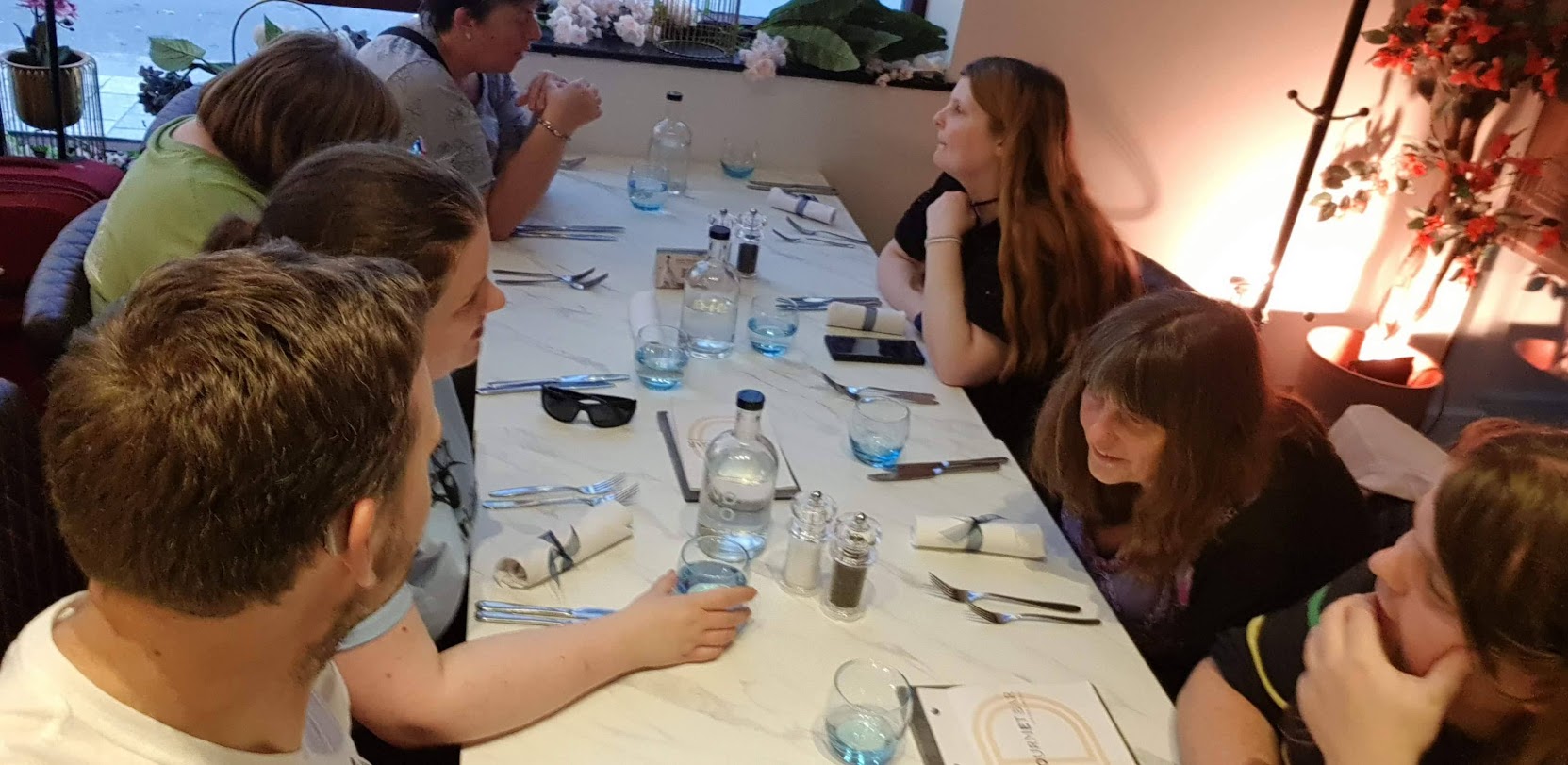 Seven people with aniridia at a dinner table talking to each other