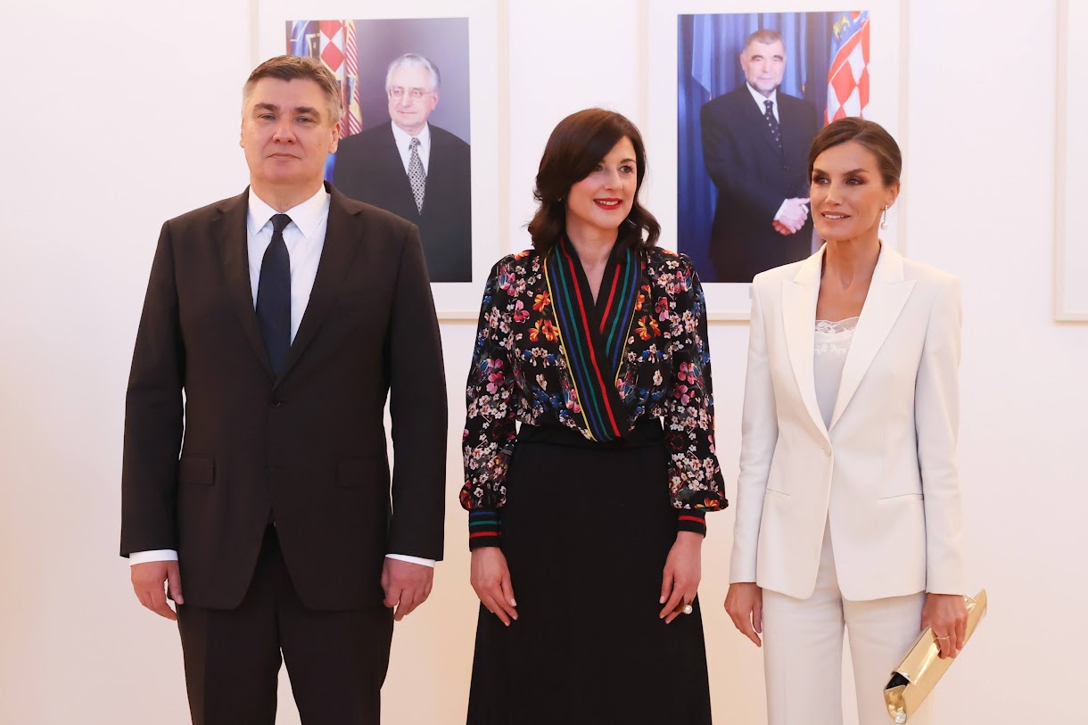 Queen Letizia of Spain wore white Hugo Boss suit with white Camisole, Magrit golden clutch and slingback pumps, Diamond and pearl earrings and Corterno ring for Croatia arrival in 2023. More details in Regalfille. 