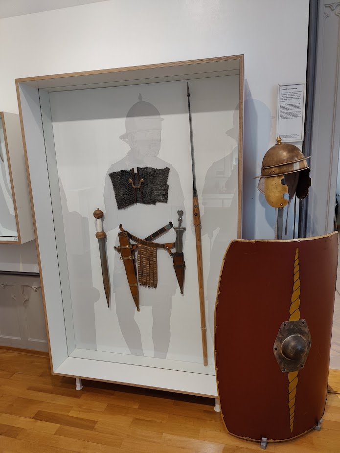 Parts of a Roman soldier outfit (a breast plate, some swords, a shield, and a helmet)