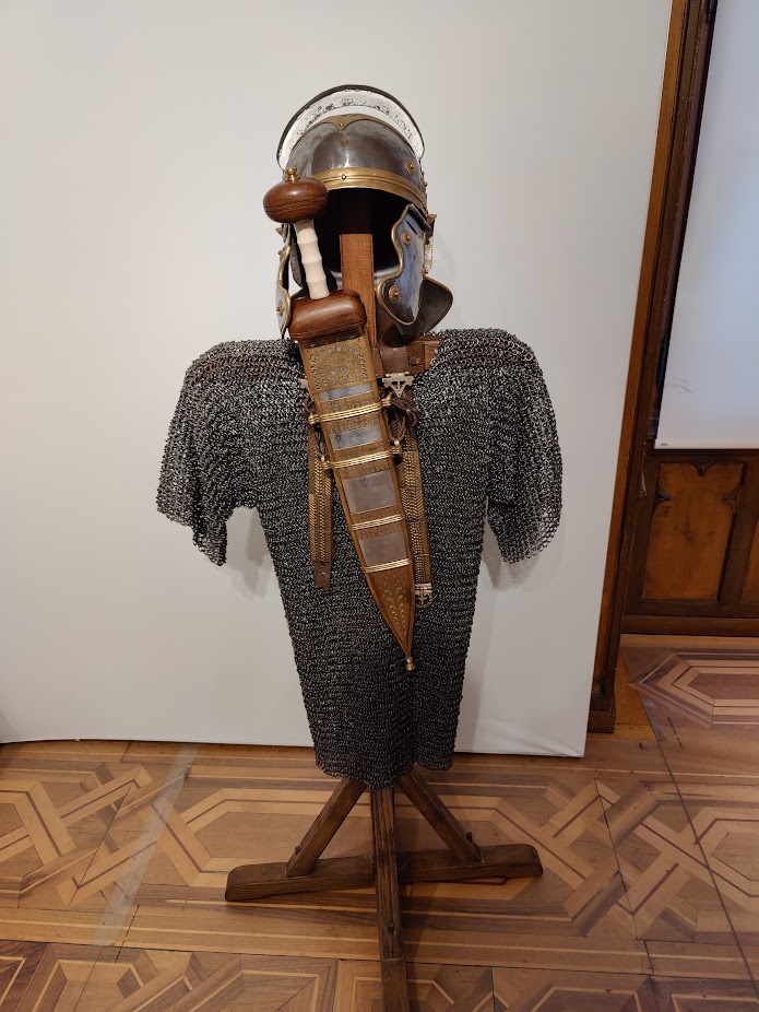 Parts of a Roman soldier outfit (a helmet, a chainmail, and a sword)