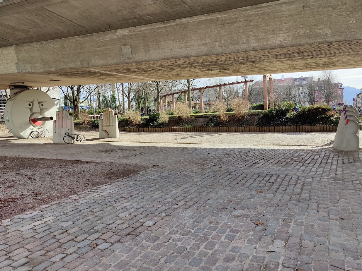 A bridge with a human-like statue underneath (the statue only has a stone as a head, there are two hands, and then two feet - it looks as if the rest of the body is underground)