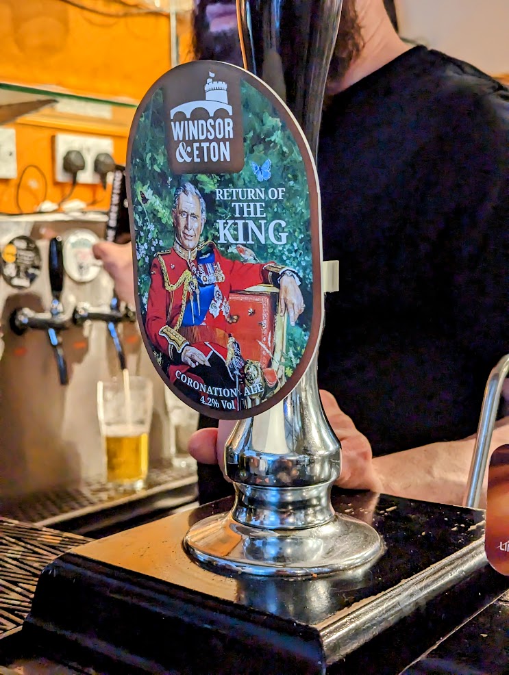 ‘Return of the King’ beer on ale pump at pub. Image has King Charles on the branding