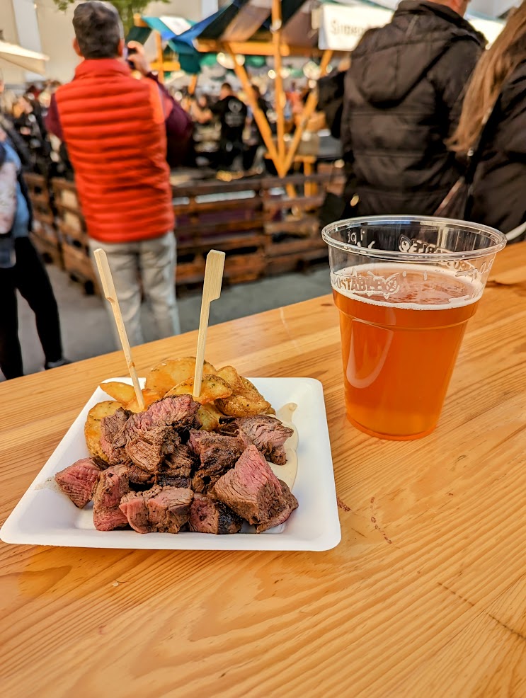 Steak and chips with a beer on a wooden table