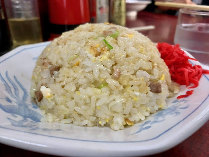 丸く盛られたチャーハン。脇には赤い紅生姜がある。