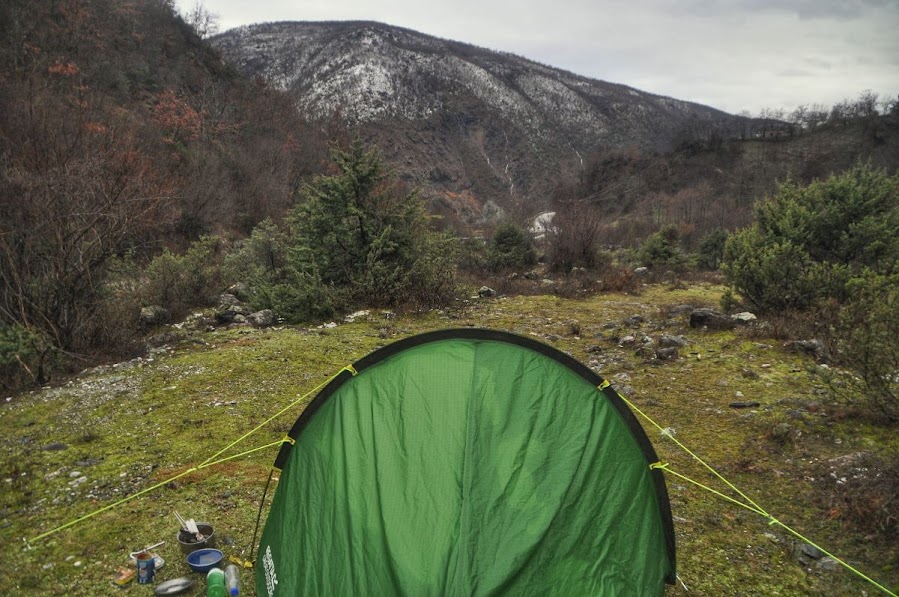 A tent camped on grass inside a gorge in Fierze, Shkoder County, Albania