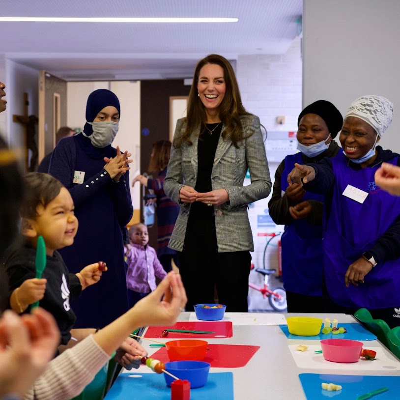 Catherine met volunteers and attendees of their weekly MumSpace group, pairing her LK Bennett Frieda Crepe Cigarette Trousers in black with a sleek new monochrome Glen Check Catherine Walker jacket