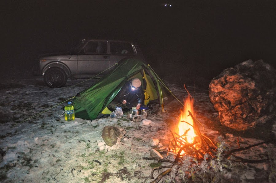 A car and a tent parked in front of a man-made fire in Bajram Curri, Kukes County, Albania