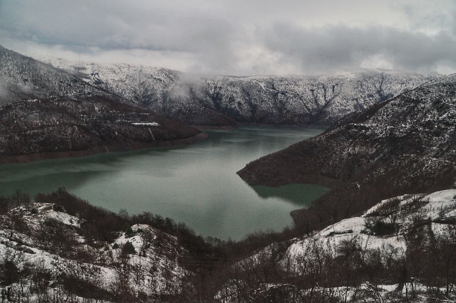 A lake surrounded by snowy mountains in Fierze, Shkoder County, Albania. 
