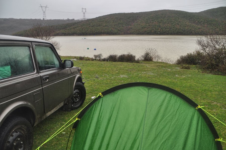 A car and a tent parked by Drini Lake in Shkoder County, Albania