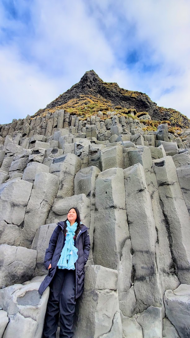 South Iceland Waterfalls and Black Sand Beach: Reynisfjara Black Beach is stunning - you can see the the arched cliff of Dyrhólaey looming over the sea. You can walk on the black sand with pounding Atlantic waves to basalt stacks reminiscent of a pyramid of organ pipes. Out in the roaring sea, you can see sea stacks that may have once been trolls