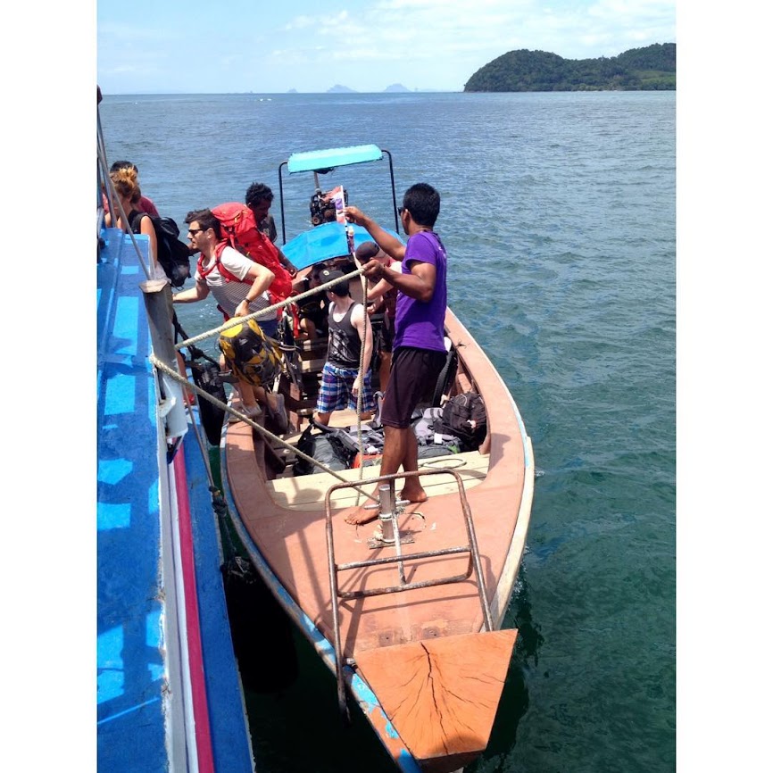 embarking on longtail boat in adamant sea in thailand 