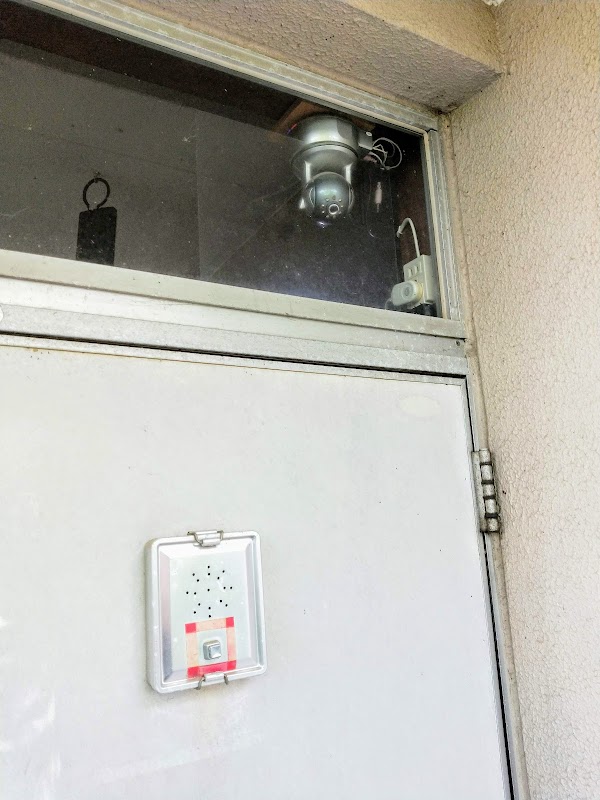 玄関に設置したIPカメラ。戸の上の採光窓を通して内側から外を監視する。