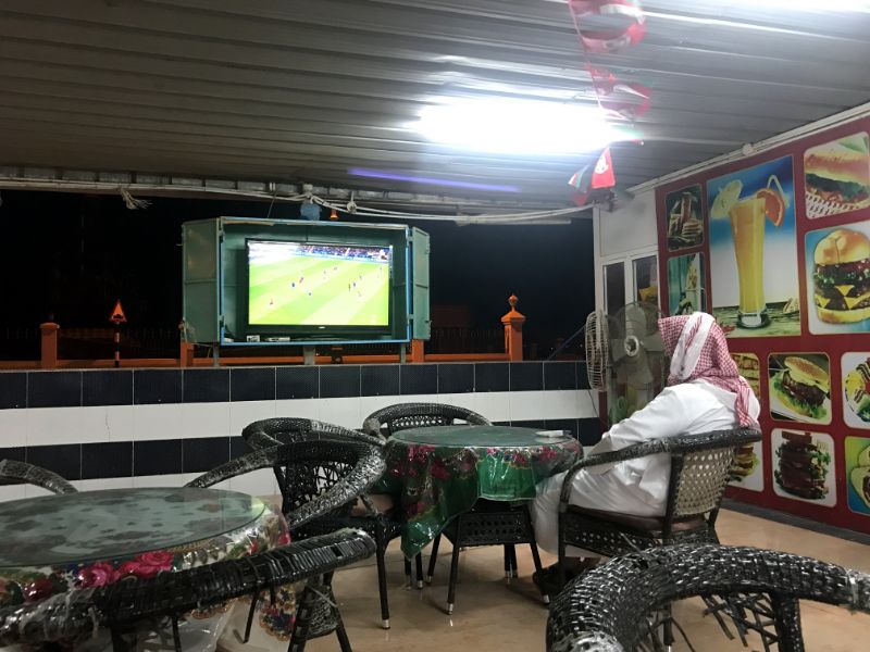 Omani man watching a football game at restaurant in sur city