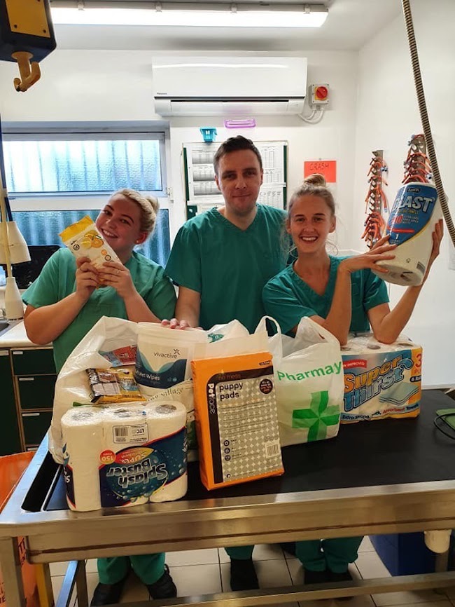 A student vet nurse, a veterinary care assistant and a vet nurse pose with donated goods from the public at PDSA Pet Hospital Huyton, Liverpool