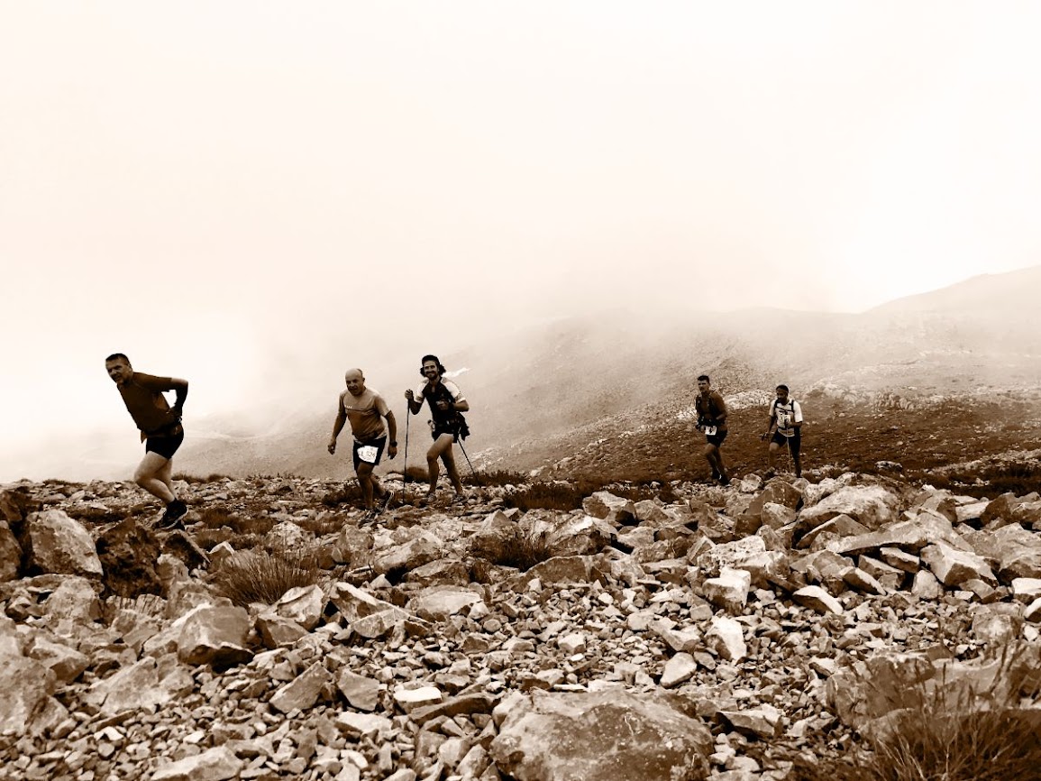 mountain marathon runners while passing by the top of mount kyllini while in a race in greece