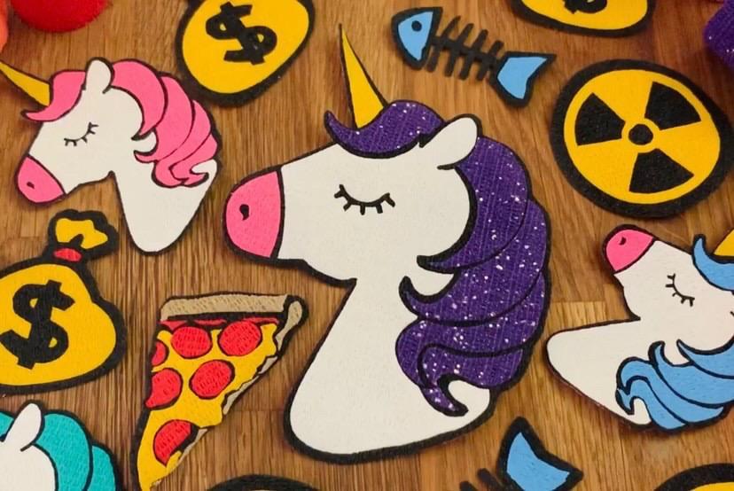 A collection of Bandage Art patches including a large purple unicorn and a pizza slice
