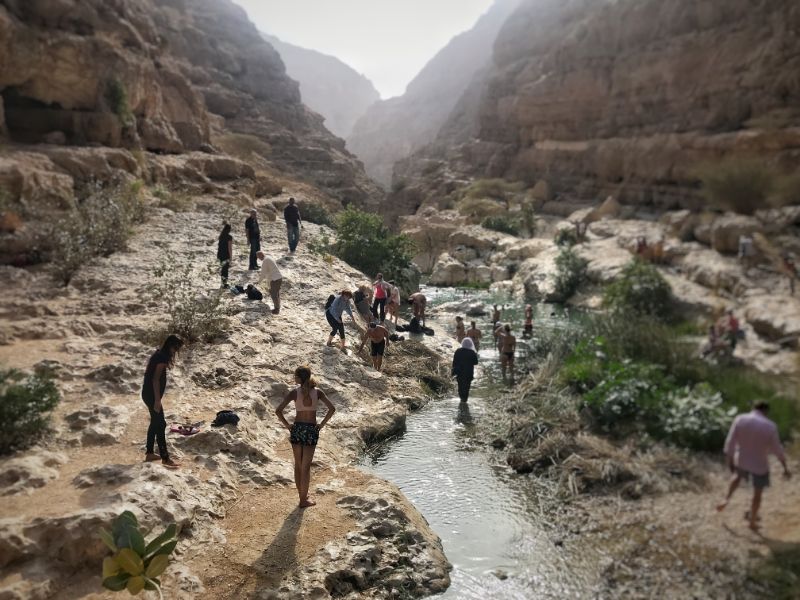 tourists swimming in pool in wadi shab canyon oman