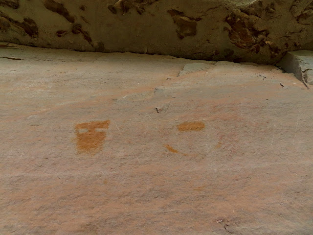 Orange pictographs and a very faded red figure