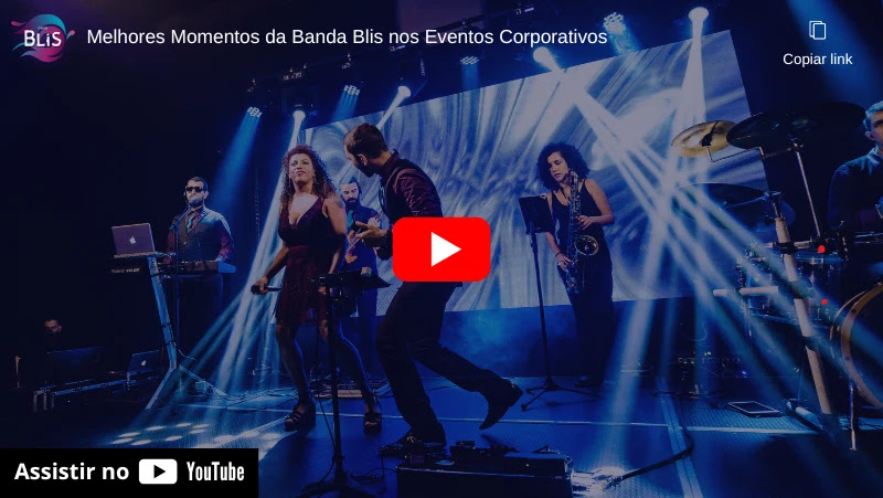 Banda se apresentando ao vivo, com iluminação cênica e instrumentos musicais. A energia do show atrai a atenção do público.