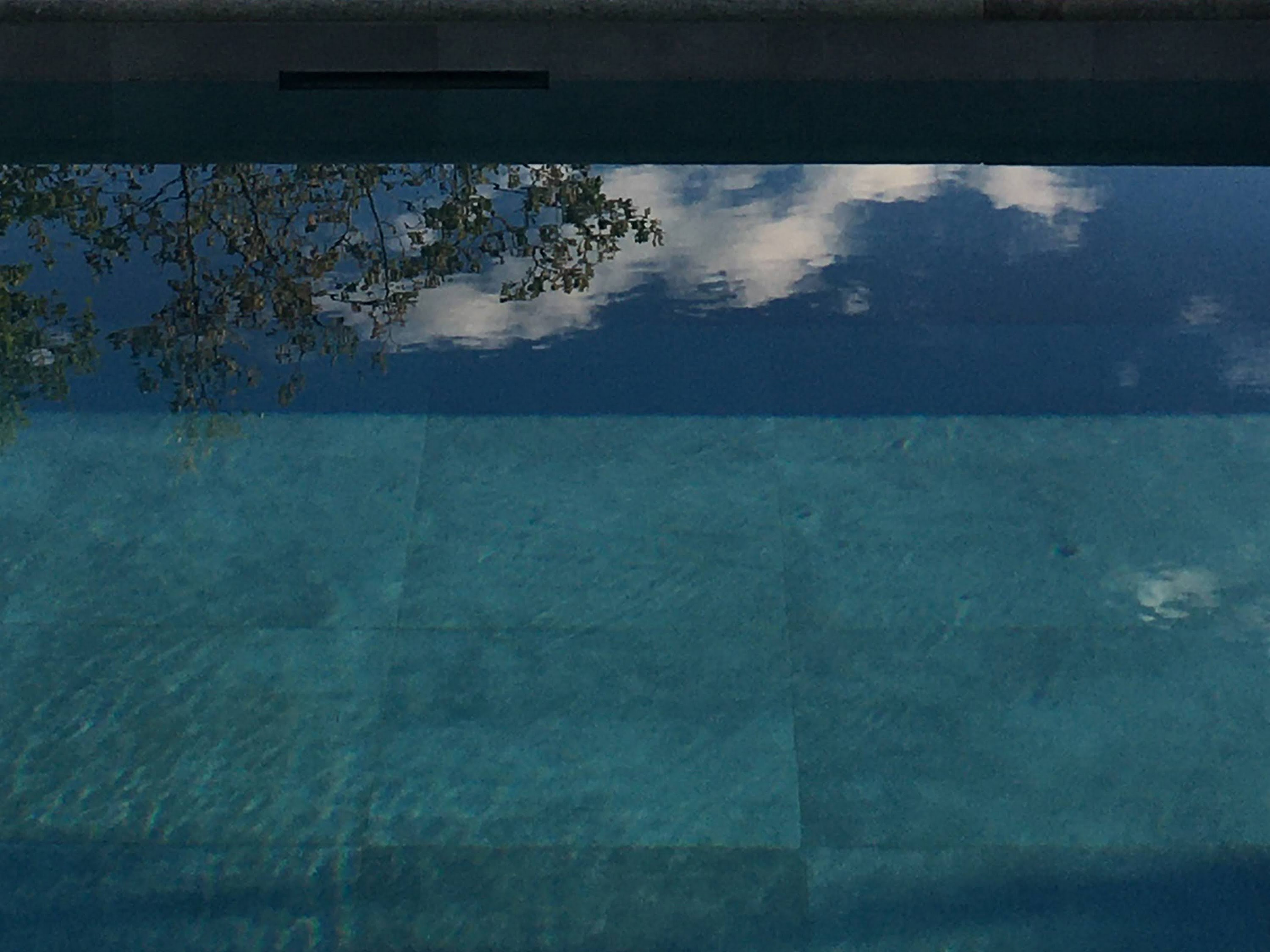 Close up of the serene water in swimming pool reflection white clouds and blue sky“/> </a>
</td>
        </tr>
        <tr>
          <td align=