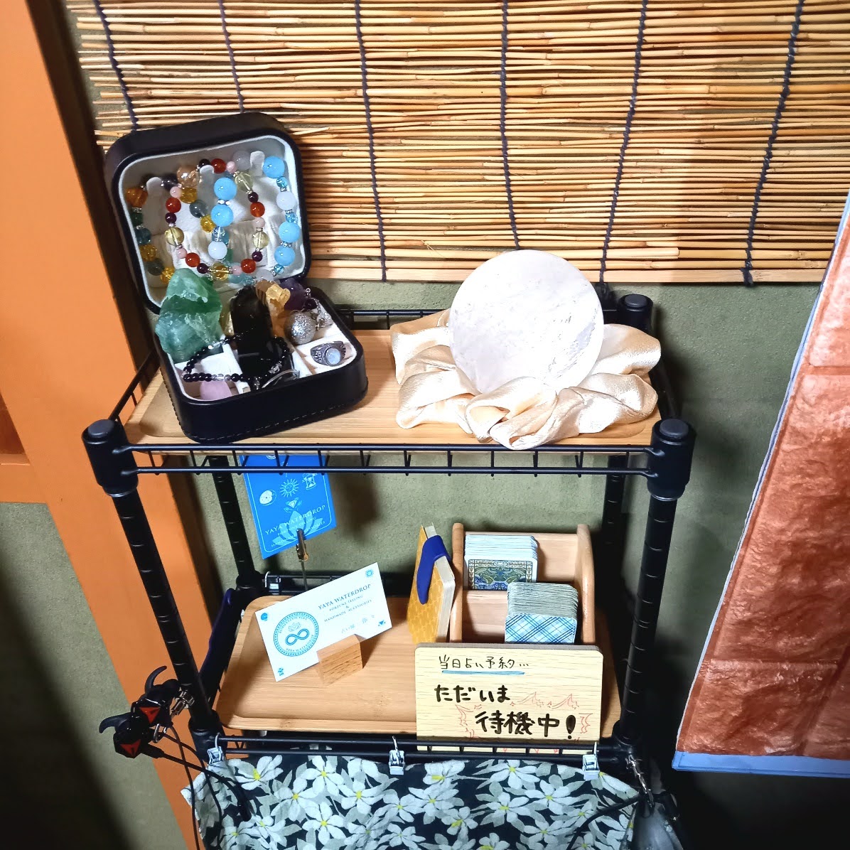 机の左側はインテリア装飾とお守りを兼ねた天然石と手作りパワーストーンブレスレット置き場で、ミニサイズのタロットカードと名刺も置いています。
