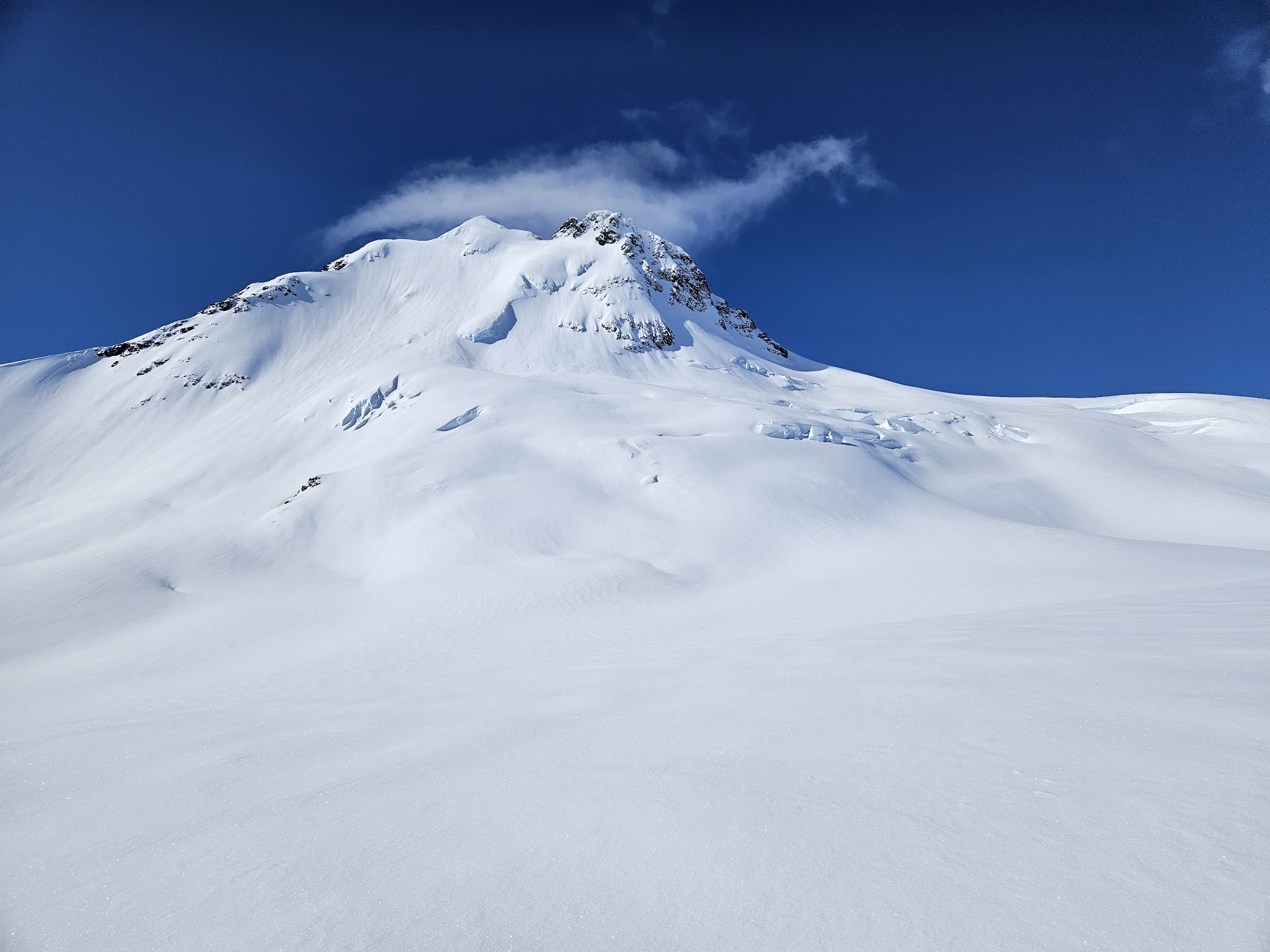 Tall, glaciated mountain with lenticular cloud