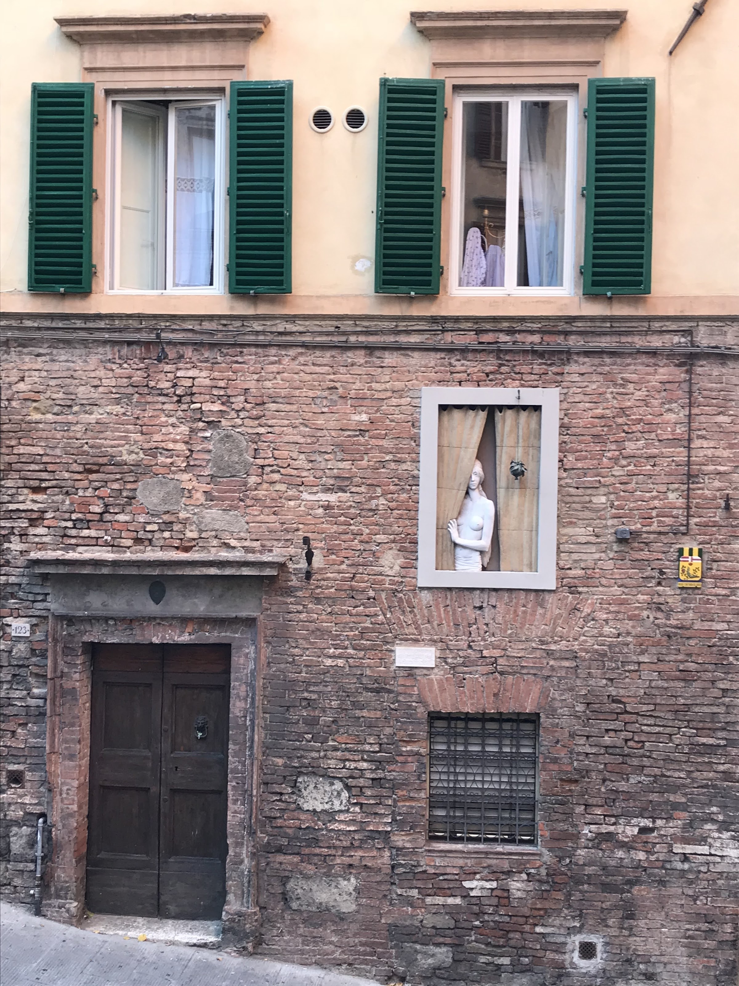 Sculpture of a Young Woman Peeking Out of Window