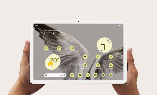 Dos manos sostienen una Pixel Tablet que muestra el tiempo y la información en la pantalla frontal.