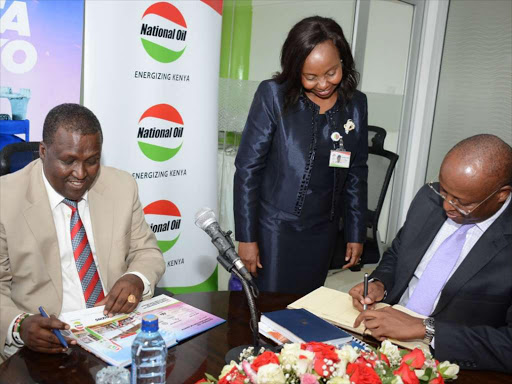 Petroleum and Mining PS Andrew Kamau signs the visitor’s book after paying ex-National Oil CEO Maryjane Mwangi a courtesy call