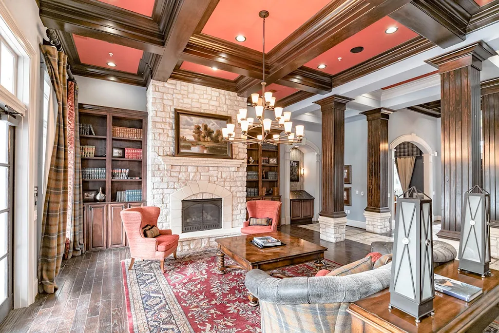 Clubhouse interior with dark wood flooring, a stone fireplace, and seating area