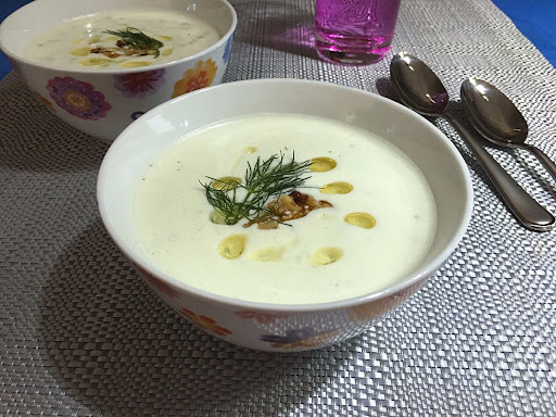 A delicious cold tarator soup garnished with chopped roasted walnuts, fresh dill and walnut oil.