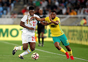 Senegal's Lamine Gassama, left, fights for the ball with Bafana Bafana's Sibusiso Vilakazi during their Word Cup qualifier match at Peter Mokaba Stadium in Polokwane on Friday. Bafana lost 2-0 and crashed out of the 2018 football extravaganza. / Siphiwe Sibeko / Reuters