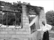 FIRE TRAGEDY: Sowetan reporter Riot Hlatshwayo next to the burnt out shell of the house. Pic. Alfred Moselakgomo. © Sowetan.