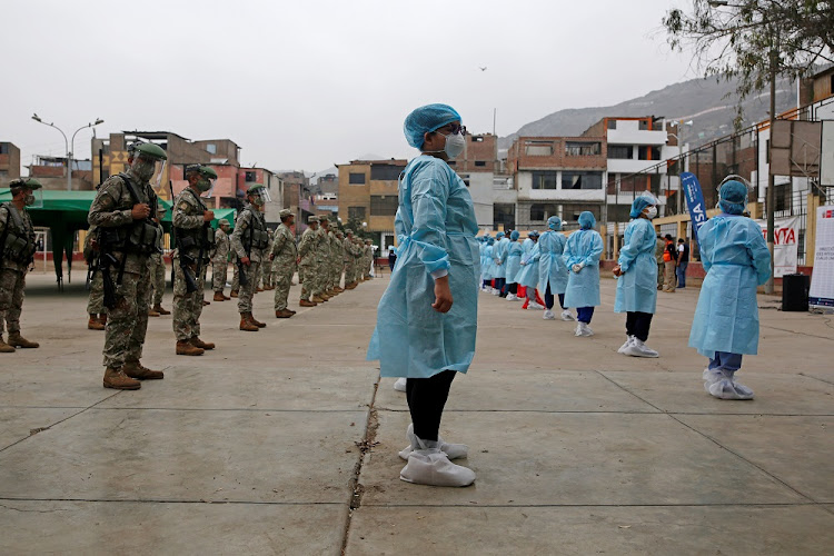 Medical workers and soldiers stand together before doing mass testing for the coronavirus disease (COVID-19) in Lima, Peru, January 7 2021.