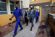 Former Kenyan sports minister Hassan Wario is escorted by security officers after he was found guilty of corruption charges in connection with the 2016 Rio Olympics funds, at the Milimani Law Courts in Nairobi, Kenya on September 16, 2021. 