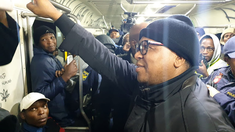 Transport minister Fikile Mbalula chats to commuters on a Metrorail train from Khayelitsha to Langa in Cape Town that started an hour late and never reached its destination. The train's seats had been ripped out, most of the windows had been removed and there was graffiti all over the carriage.