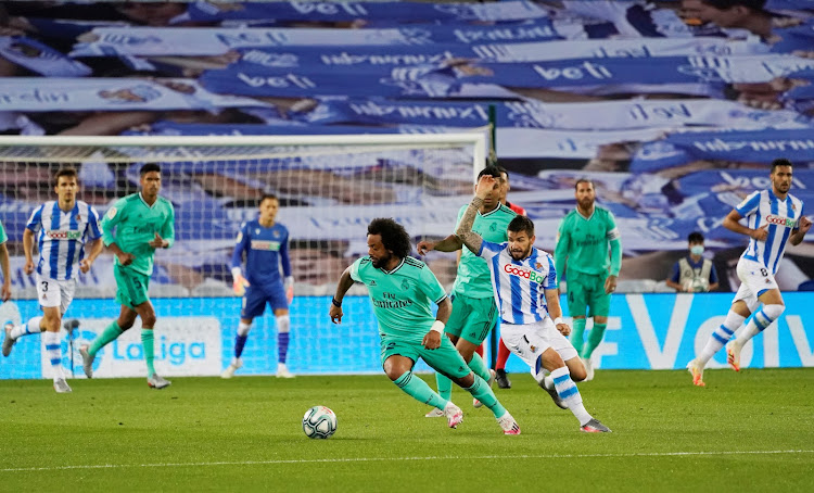 Real Madrid's Marcelo in action with Real Sociedad's Portu, as play resumes behind closed doors following the outbreak of Covid-19.