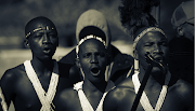 Three initiates run through the village, singing praise songs to their ancestors and the king. They are accompanied by the young men who looked after them in the 'bandla' (their sleeping place in the 'Mountains of Manhood').