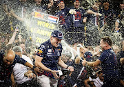 Max Verstappen celebrates with his team after winning the Formula 1 World Championship after the Abu Dhabi Grand Prix at the Yas Marina Circuit.