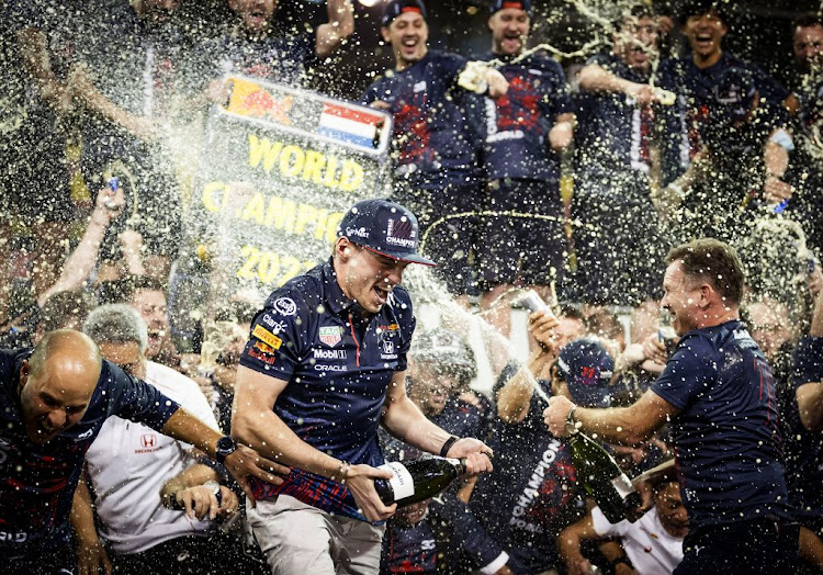 Max Verstappen celebrates with his team after winning the Formula 1 World Championship after the Abu Dhabi Grand Prix at the Yas Marina Circuit.