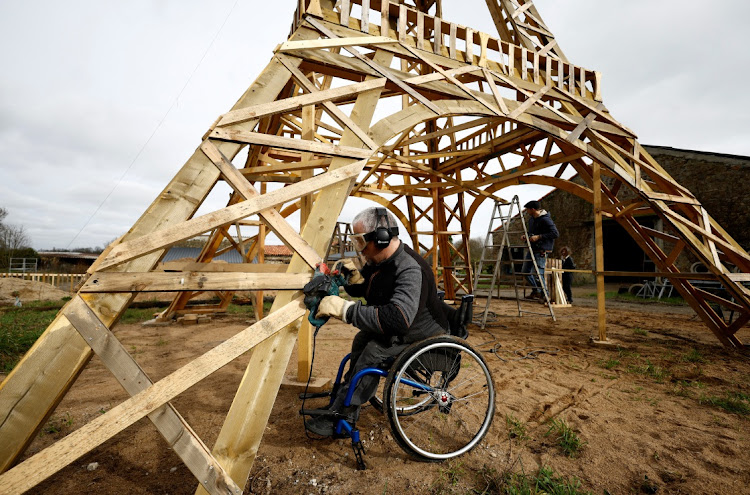 Sylvain Bouchard, a sports enthusiast with disability, work on a 16-meter replica of the Eiffel Tower.